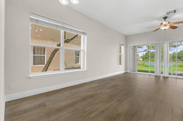 unfurnished room featuring a ceiling fan, visible vents, baseboards, and wood finished floors