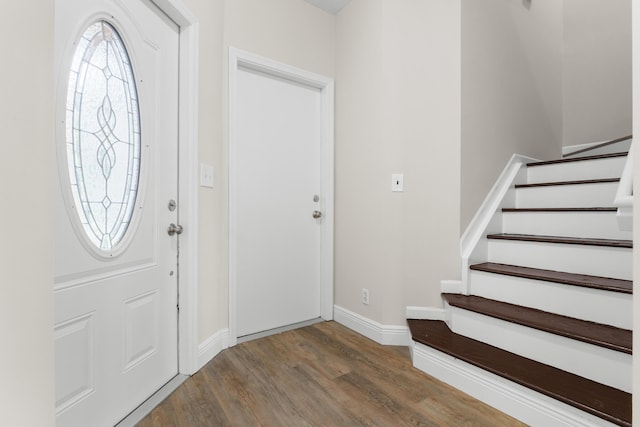 foyer with stairs, wood finished floors, and baseboards