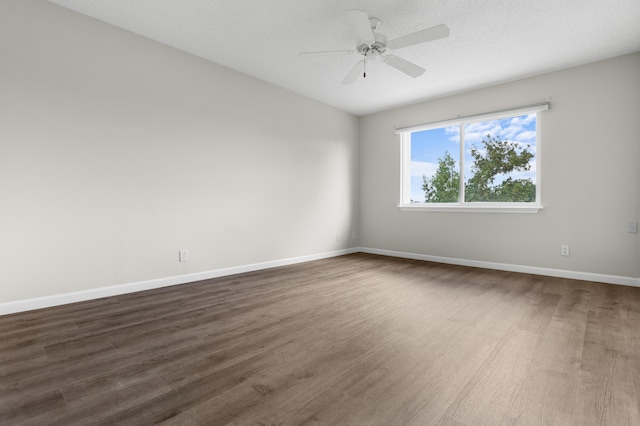 spare room featuring a ceiling fan, a textured ceiling, baseboards, and dark wood-style flooring