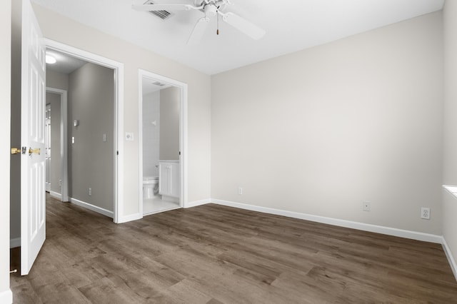 spare room with a ceiling fan, visible vents, baseboards, and wood finished floors