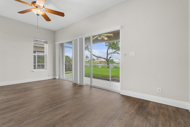 spare room featuring a ceiling fan, a healthy amount of sunlight, baseboards, and wood finished floors