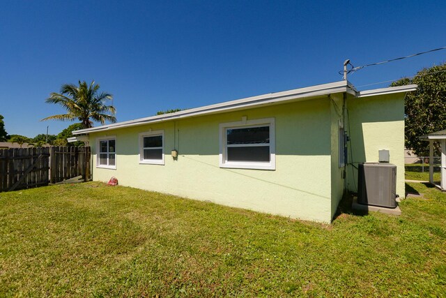 2624 S 27th St, Fort Pierce, FL 34981 - rear view of house featuring central air condition unit, a yard, stucco siding, and fence