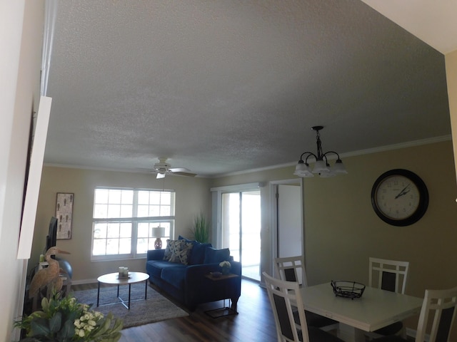 living room with baseboards, dark wood-style floors, a textured ceiling, crown molding, and ceiling fan with notable chandelier