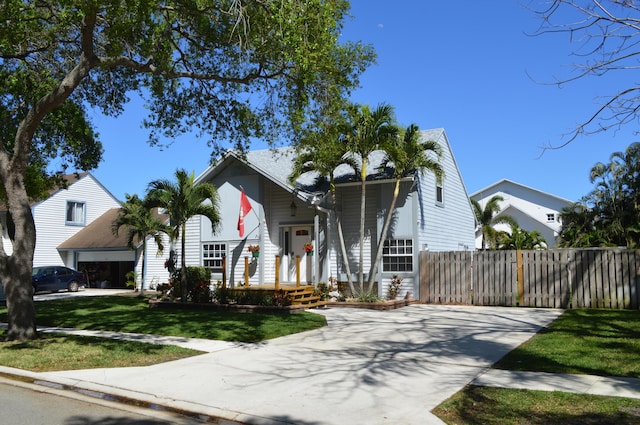 view of front facade with a garage, a front lawn, and fence