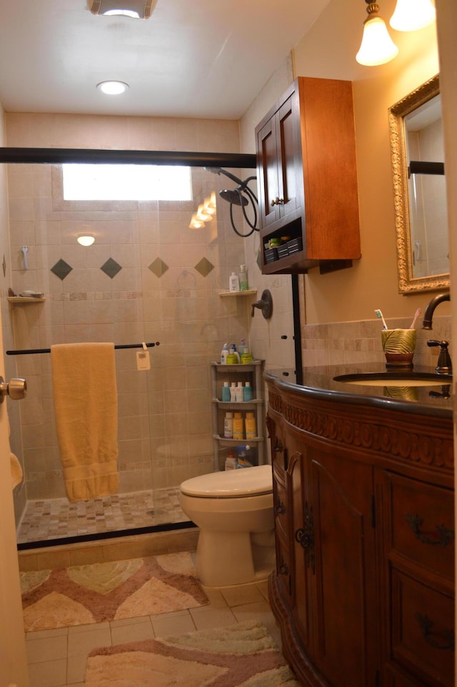 bathroom featuring toilet, a stall shower, and vanity