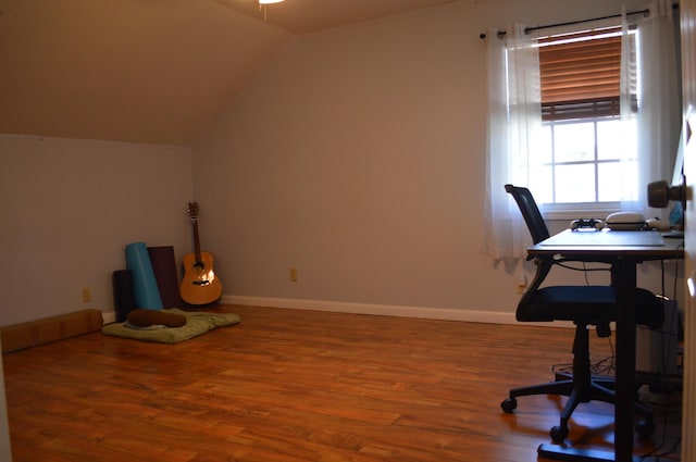 office space featuring baseboards, lofted ceiling, and wood finished floors