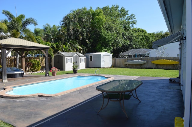 view of swimming pool featuring a patio, a shed, a fenced backyard, a gazebo, and a lawn