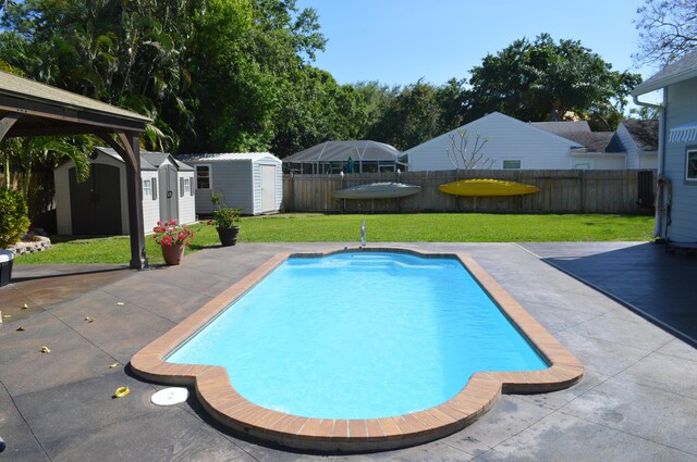 view of pool with a patio, a fenced backyard, a shed, an outdoor structure, and a fenced in pool