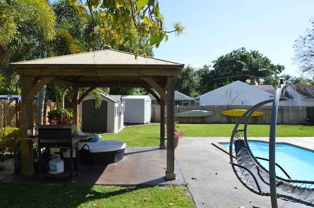 view of patio with a fenced in pool, an outdoor structure, a storage shed, and a fenced backyard