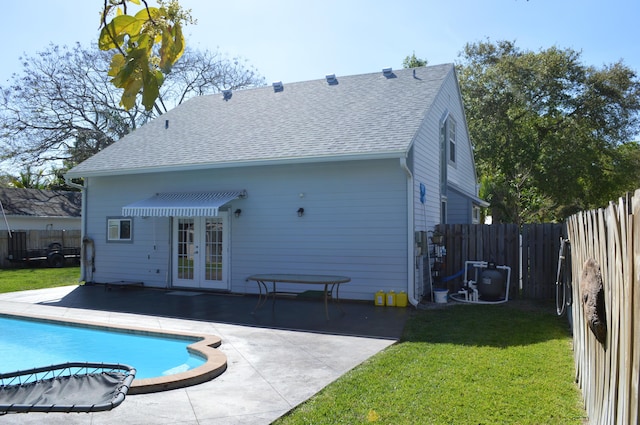 back of property with a patio area, a lawn, french doors, and a fenced backyard