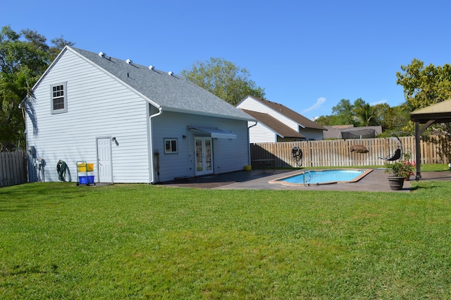 rear view of property with french doors, a patio, a fenced in pool, and a fenced backyard