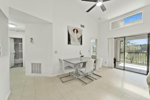 dining area featuring high vaulted ceiling, visible vents, baseboards, and light tile patterned floors