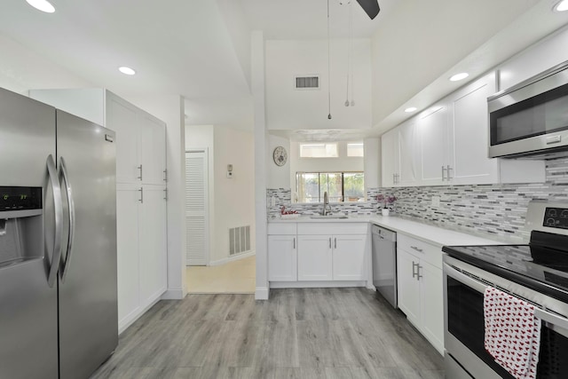 kitchen featuring white cabinets, appliances with stainless steel finishes, visible vents, and tasteful backsplash