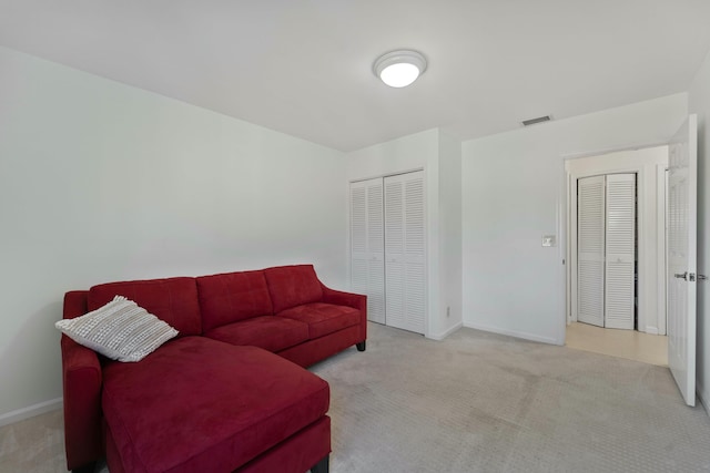 living room with baseboards, visible vents, and carpet flooring