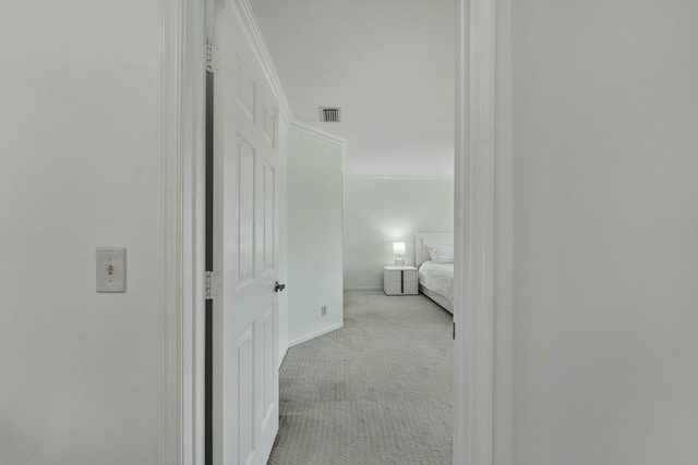 hall featuring carpet floors, visible vents, and crown molding