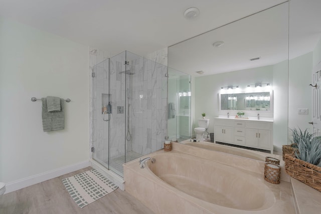 bathroom with a stall shower, baseboards, toilet, a garden tub, and vanity