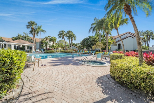 community pool with a community hot tub, fence, and a patio