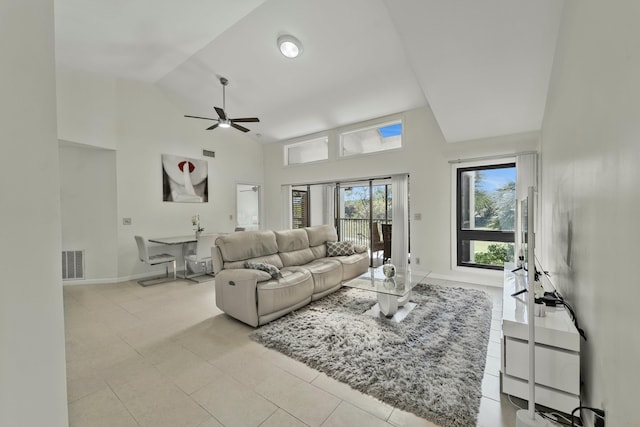 living area featuring light tile patterned floors, visible vents, baseboards, ceiling fan, and high vaulted ceiling