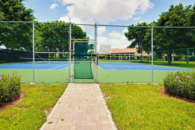 view of sport court featuring a yard, fence, and a gate