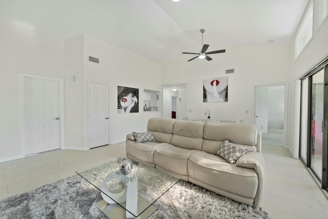 living room featuring high vaulted ceiling, light tile patterned flooring, and visible vents