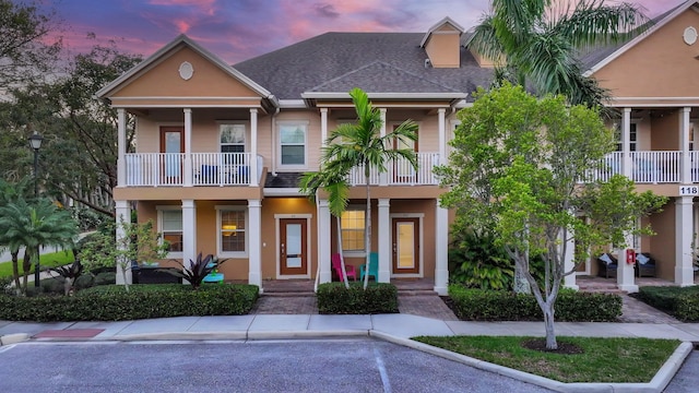 view of front of house featuring stucco siding and a shingled roof