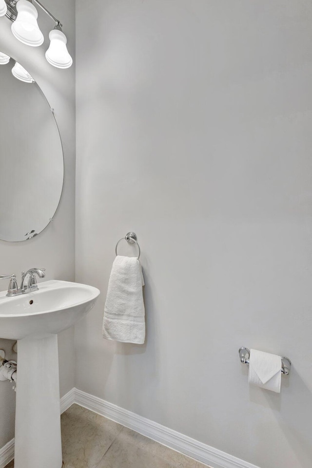 bathroom featuring tile patterned flooring, baseboards, and a sink