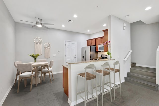 kitchen featuring visible vents, brown cabinets, recessed lighting, stainless steel appliances, and light tile patterned floors