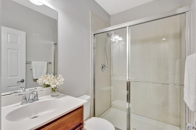 full bathroom featuring vanity, toilet, and a stall shower