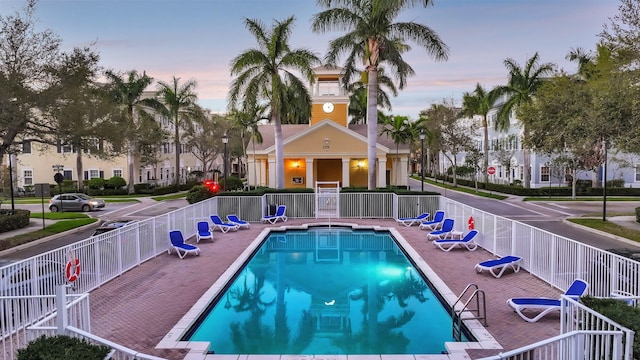 community pool with a patio and fence