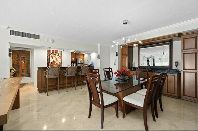 dining space featuring indoor bar, visible vents, a chandelier, and crown molding