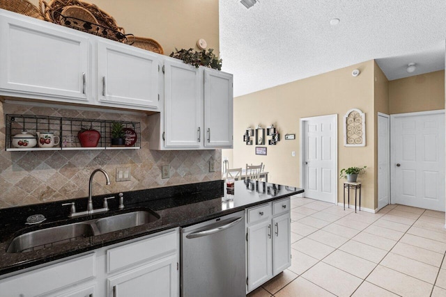 kitchen featuring white cabinets, light tile patterned flooring, a sink, and stainless steel dishwasher