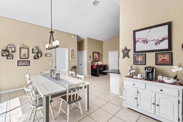 dining space featuring light tile patterned floors, visible vents, an inviting chandelier, vaulted ceiling, and baseboards