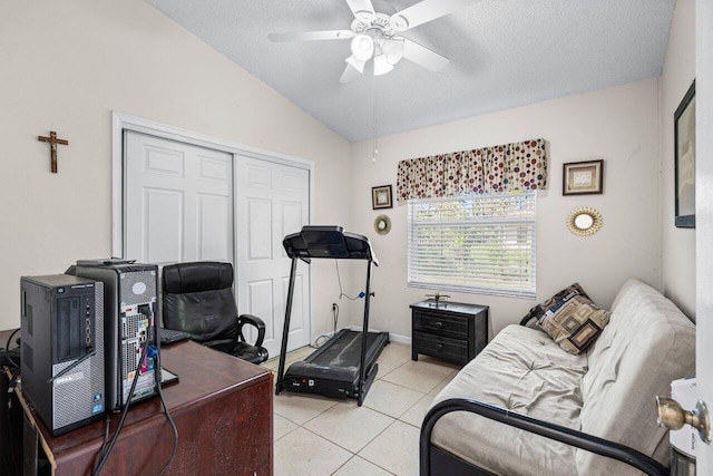 interior space with vaulted ceiling, ceiling fan, light tile patterned floors, and a textured ceiling