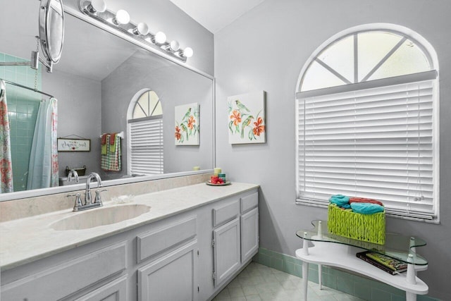 bathroom featuring curtained shower, vanity, and baseboards