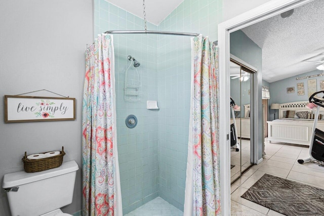 bathroom with a stall shower, lofted ceiling, toilet, and tile patterned floors