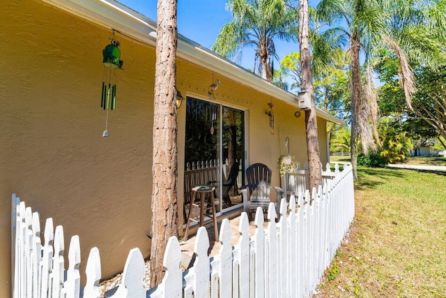 view of side of home with a lawn and stucco siding