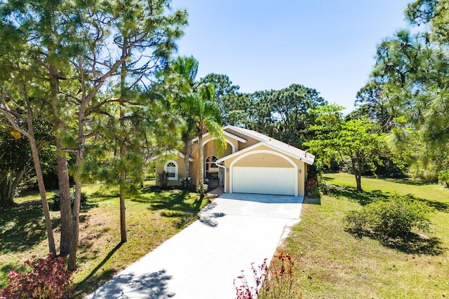 view of front of property with a garage, a front yard, concrete driveway, and stucco siding