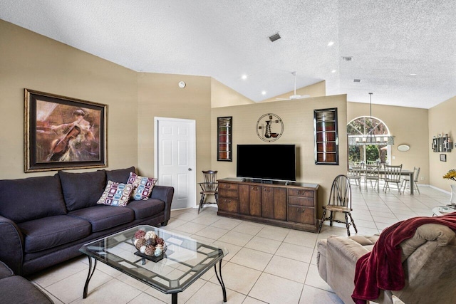 living room with lofted ceiling, a textured ceiling, light tile patterned flooring, and visible vents