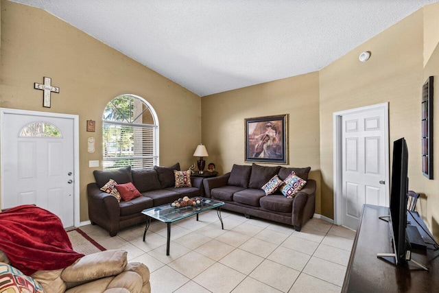 living room with vaulted ceiling, a textured ceiling, light tile patterned flooring, and baseboards