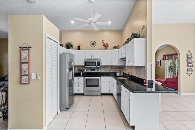 kitchen with appliances with stainless steel finishes, tasteful backsplash, a sink, and light tile patterned floors