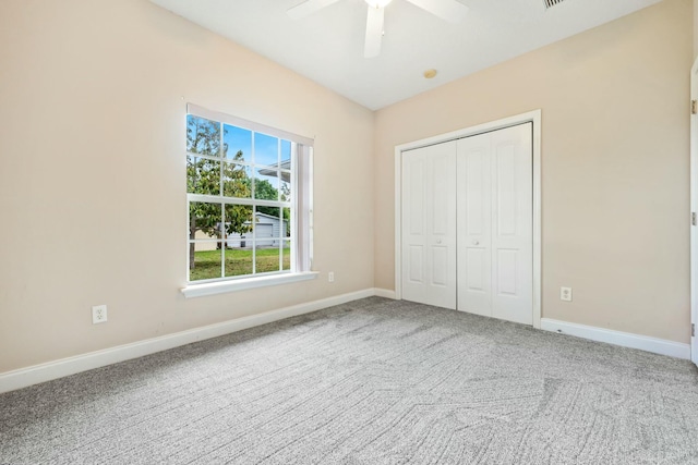 unfurnished bedroom featuring a closet, carpet flooring, a ceiling fan, and baseboards