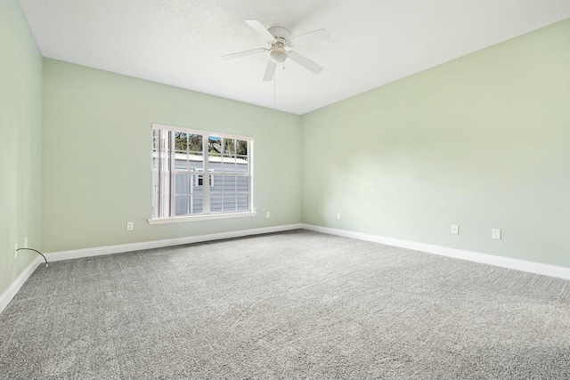 spare room featuring ceiling fan, carpet, and baseboards