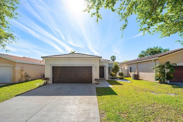 mediterranean / spanish home featuring stucco siding, a front lawn, driveway, central AC unit, and a tiled roof