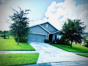 single story home with a garage, driveway, and a front lawn