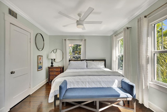 bedroom with visible vents, baseboards, ornamental molding, and dark wood-style flooring