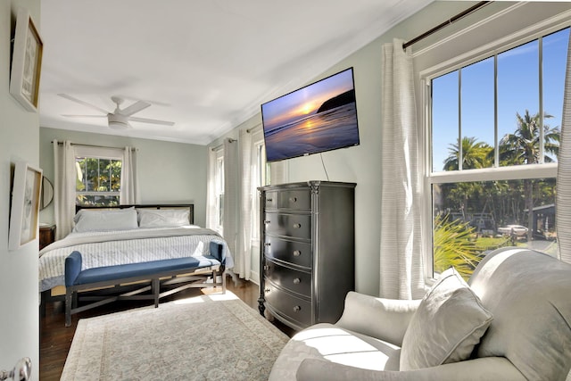 bedroom featuring ceiling fan, wood finished floors, and crown molding