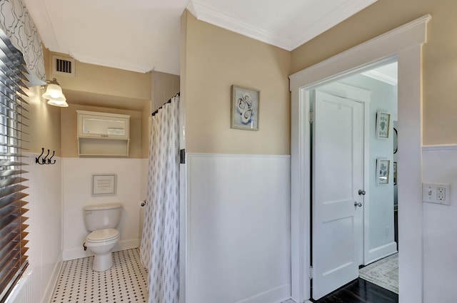 full bath with visible vents, toilet, crown molding, and a wainscoted wall