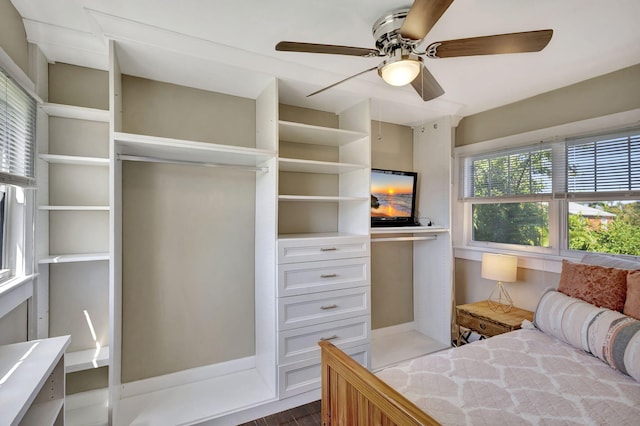 bedroom featuring ceiling fan, wood finished floors, and built in study area