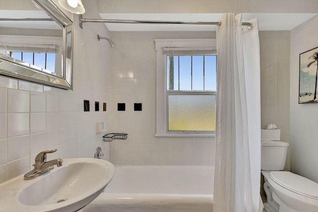 bathroom with shower / bath combo, a sink, tile walls, toilet, and tasteful backsplash