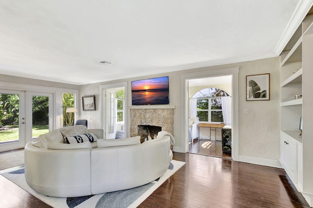 living room featuring visible vents, dark wood-type flooring, ornamental molding, french doors, and baseboards